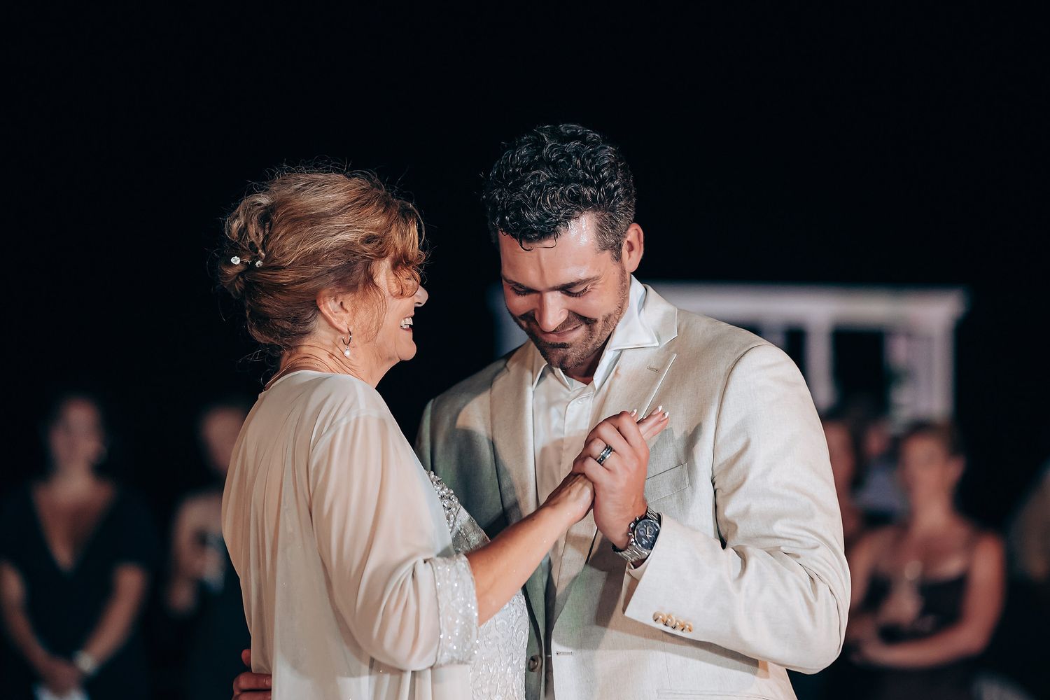 A romantic couple shares an intimate dance moment at a wedding reception in black and white photography.