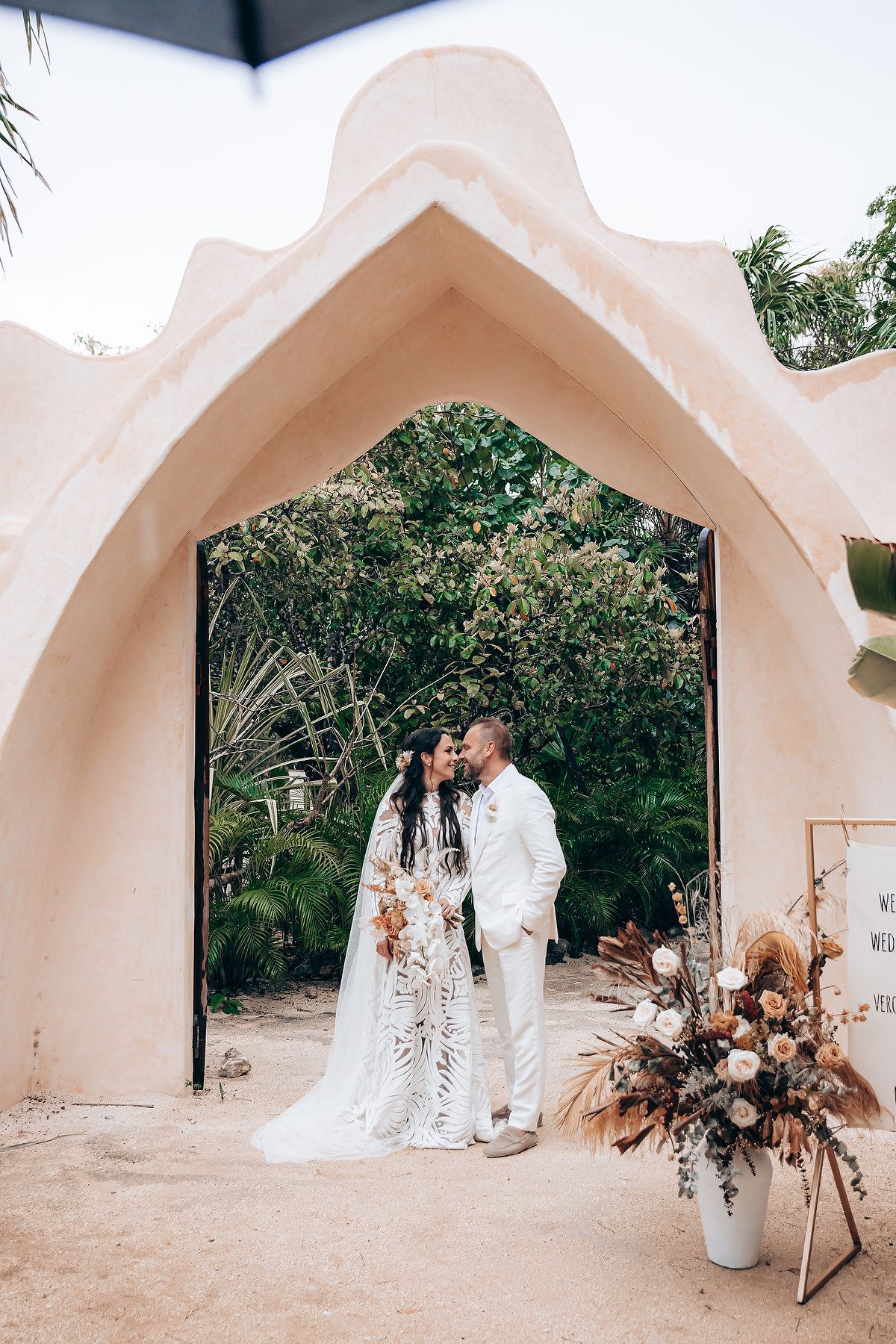 A series of five arched white architectural frames showing a romantic outdoor wedding scene with natural decor elements.
