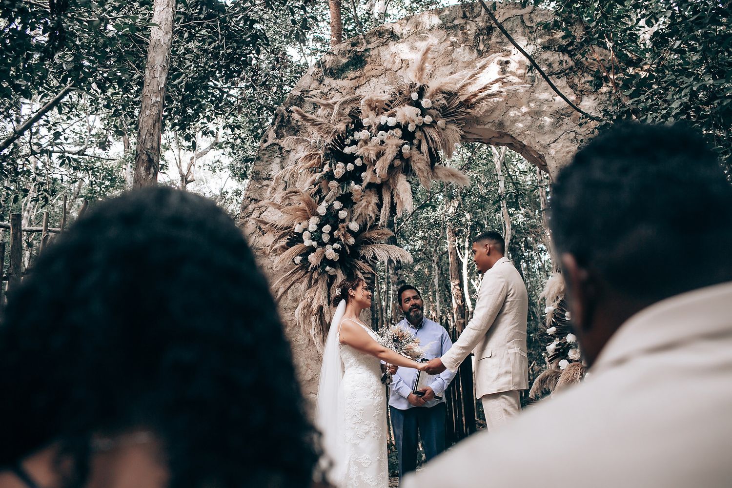 Wedding ceremony taking place in a serene woodland setting with natural decor.