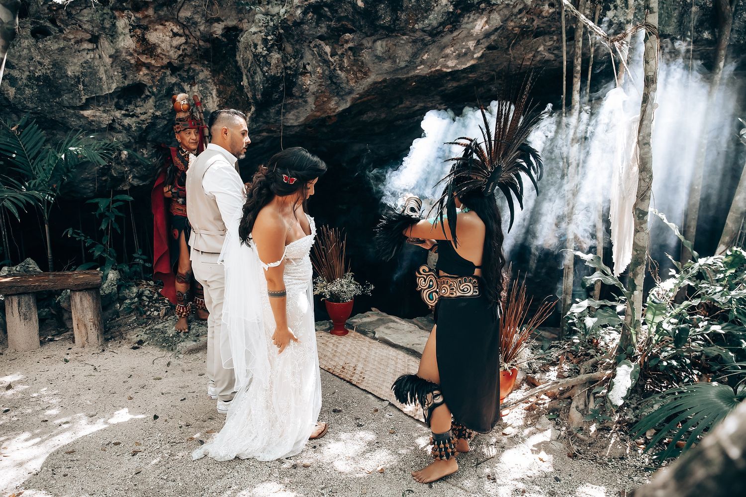 A romantic wedding photo series captured in a natural cave setting with macrame decorations and waterfall backdrop.