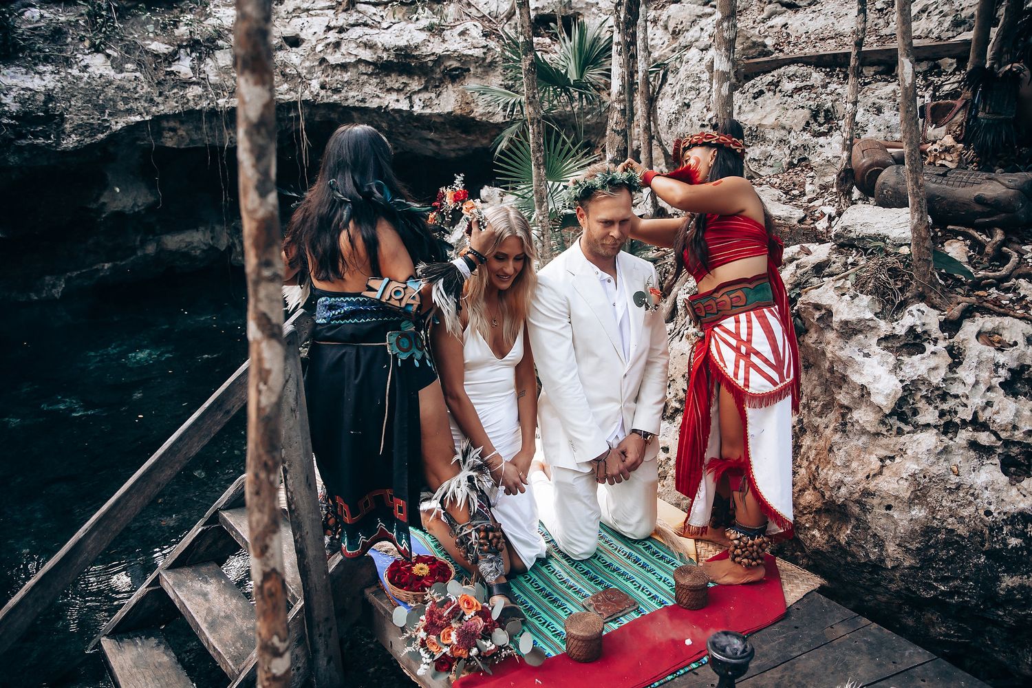 Traditional Mayan wedding ceremony taking place at ancient stone ruins with ceremonial decorations.