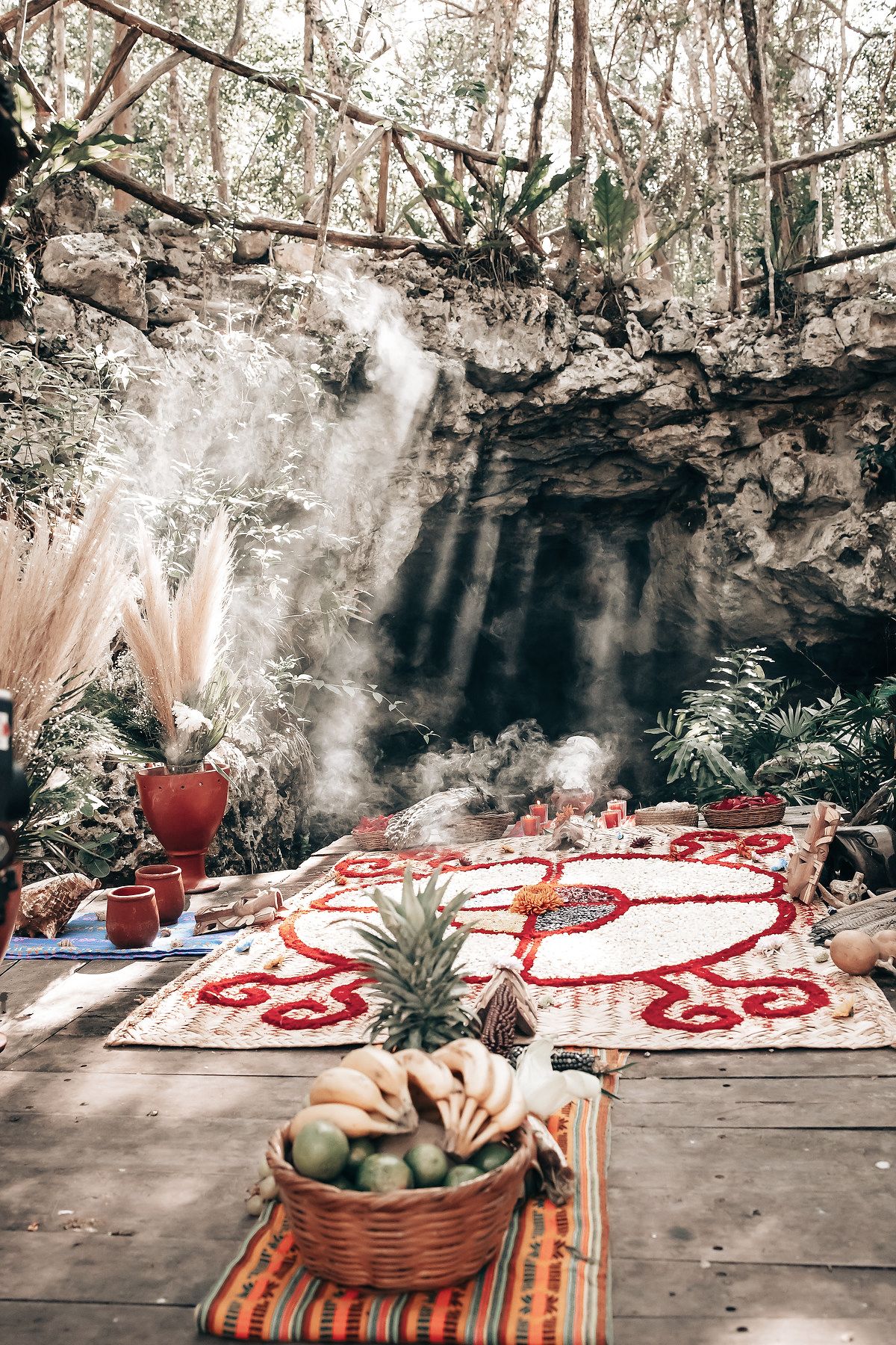 A lush, tropical waterfall scene with a wooden platform, potted plants, and a serene atmosphere.