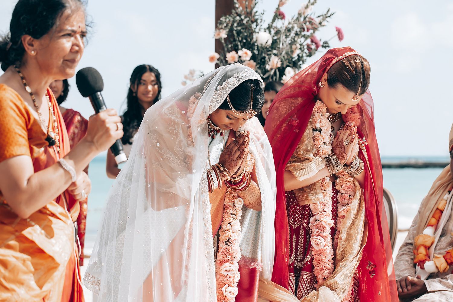 Wedding ceremony participants in colorful traditional attire gathered outdoors.