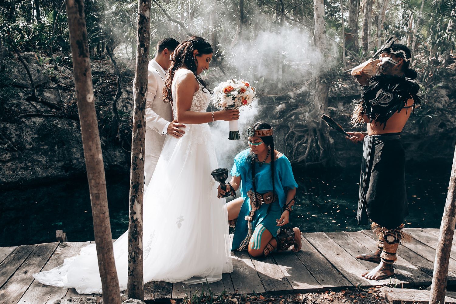 Wedding celebration in a natural cave setting with white dress against rocky backdrop.