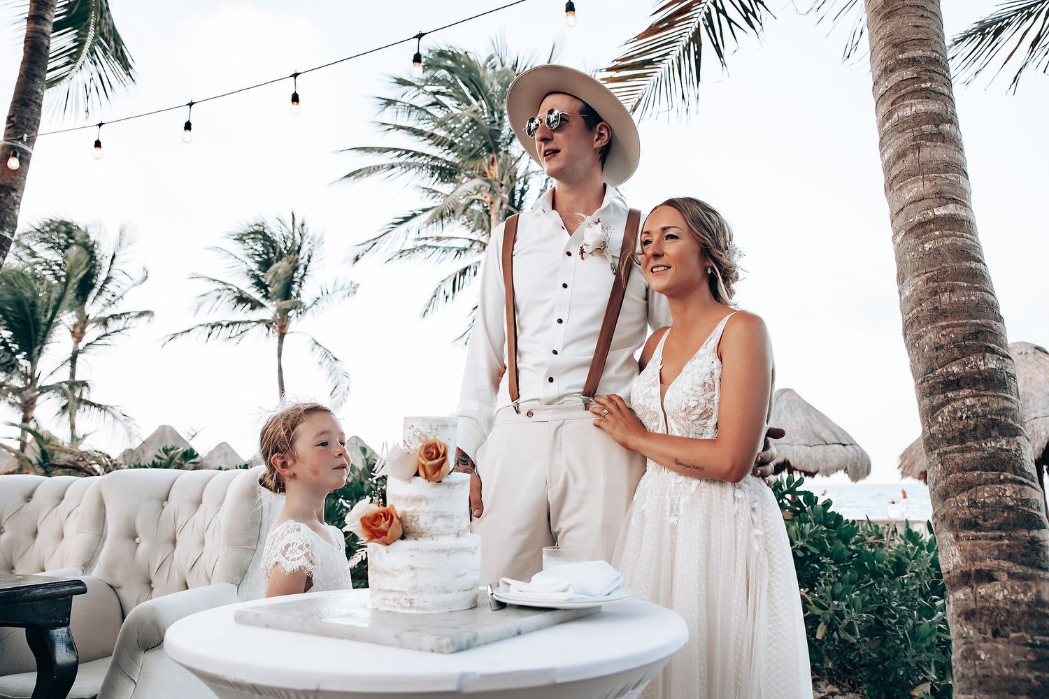 Beachside celebration with tropical decor and string lights under swaying palm trees.