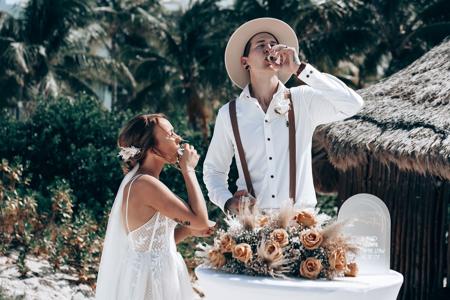 A couple shares an intimate moment at an outdoor wedding reception with floral decorations.