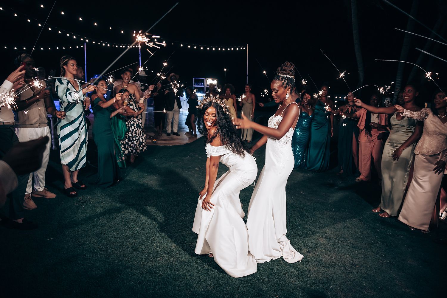 Nighttime wedding reception with guests dancing under twinkling lights.