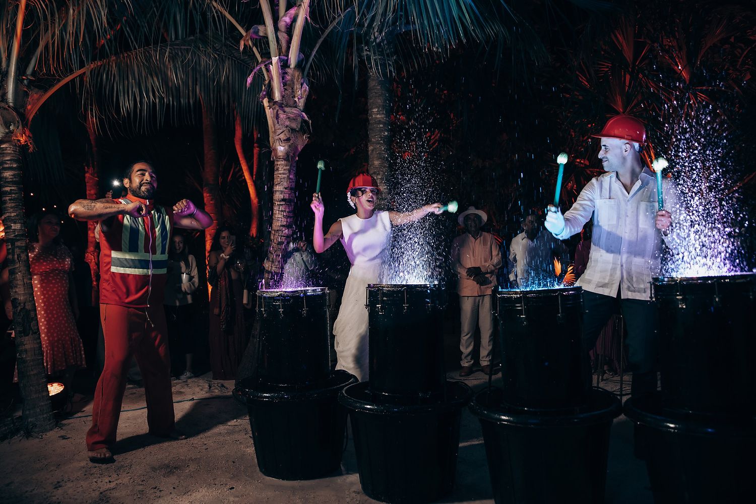 Nighttime celebration with dramatic lighting and dancing guests.