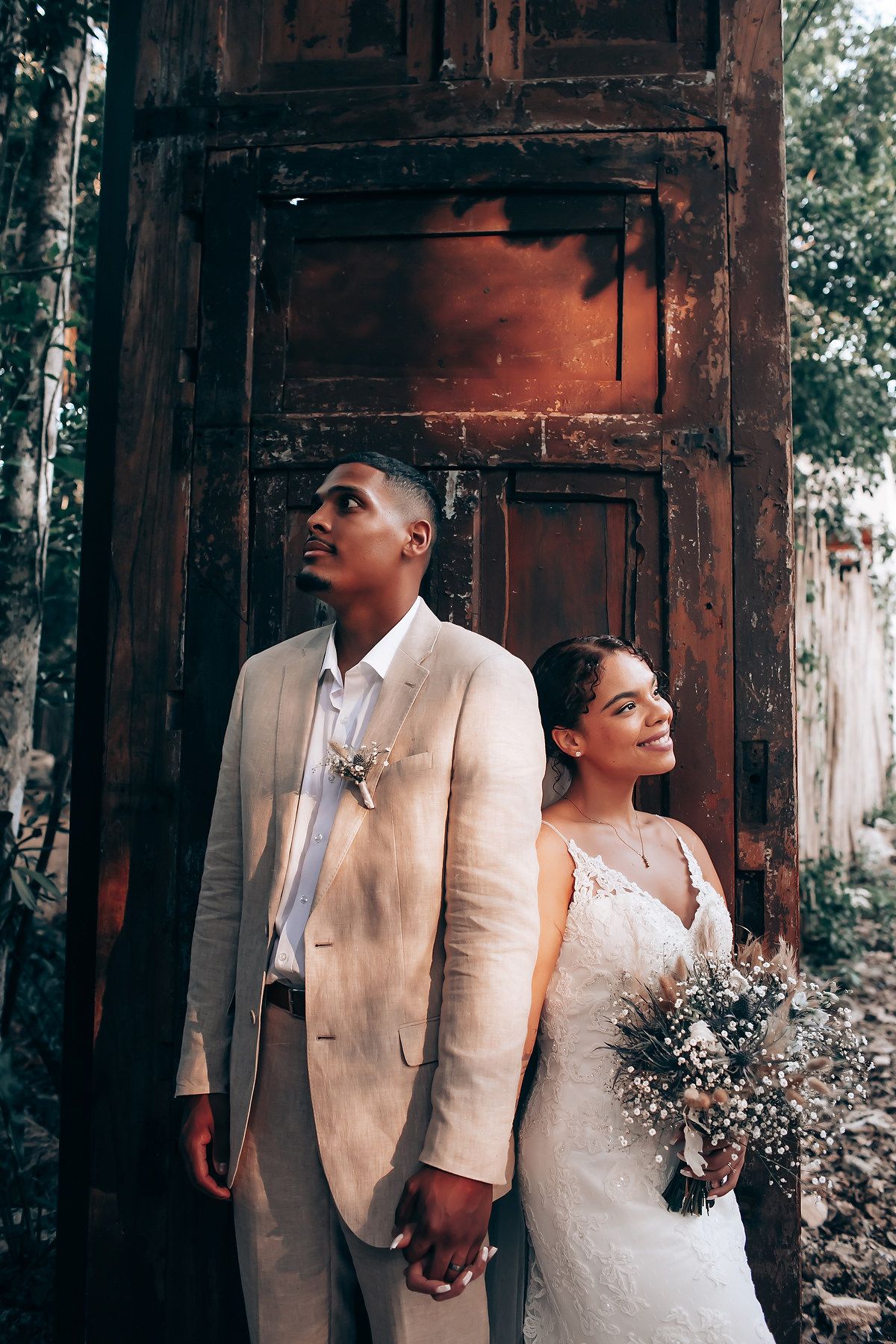 Artistic wedding portraits against weathered wooden walls in natural lighting.