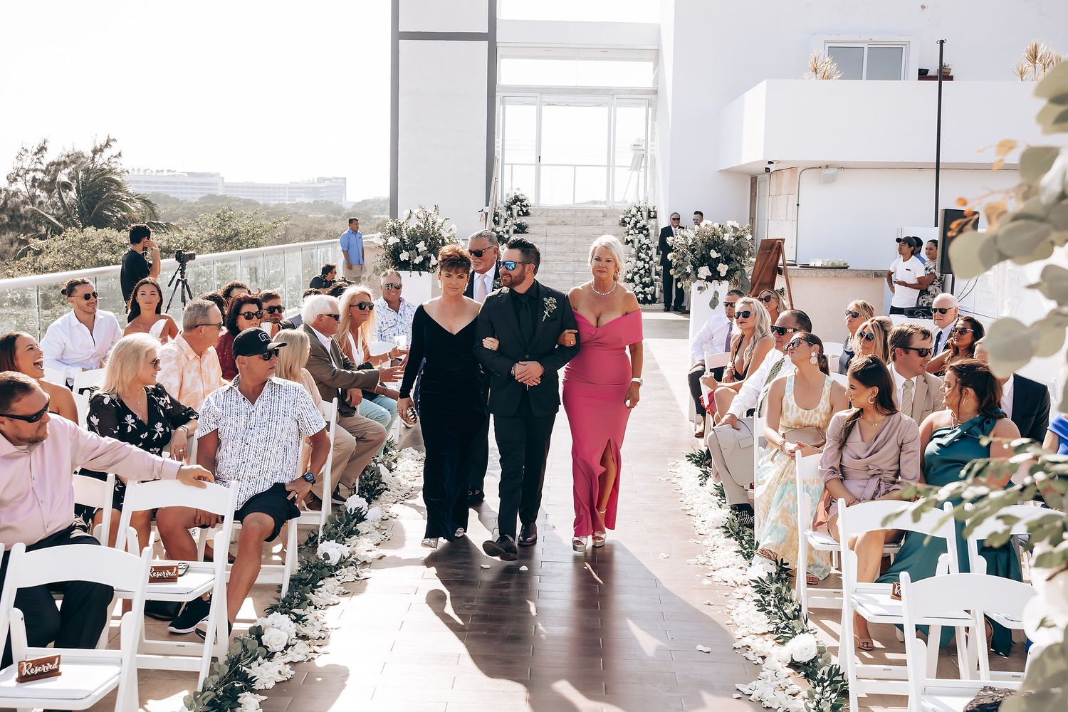 Wedding reception setup with decorated tables and guests in a bright, airy venue.