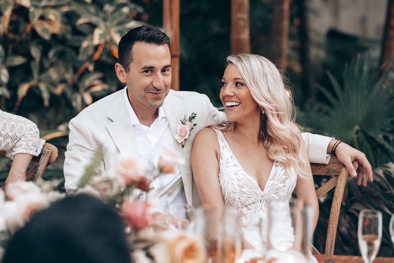 Elegant outdoor wedding reception with string lights and floral centerpieces during golden hour.