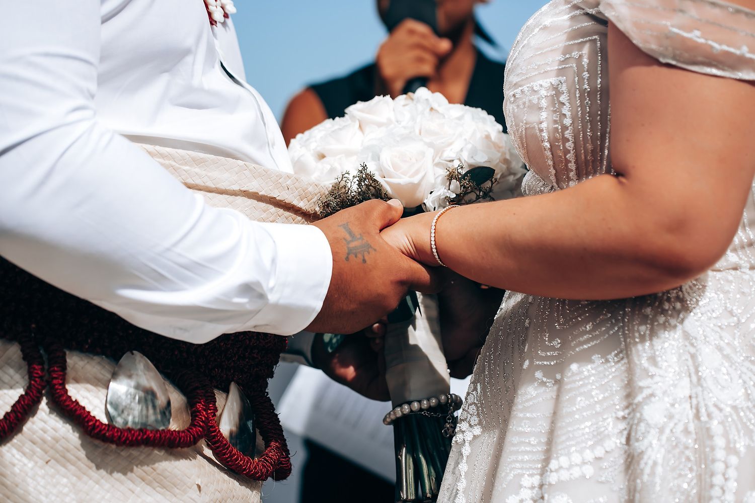 Close-up of wedding couple's hands during traditional ceremony exchange.