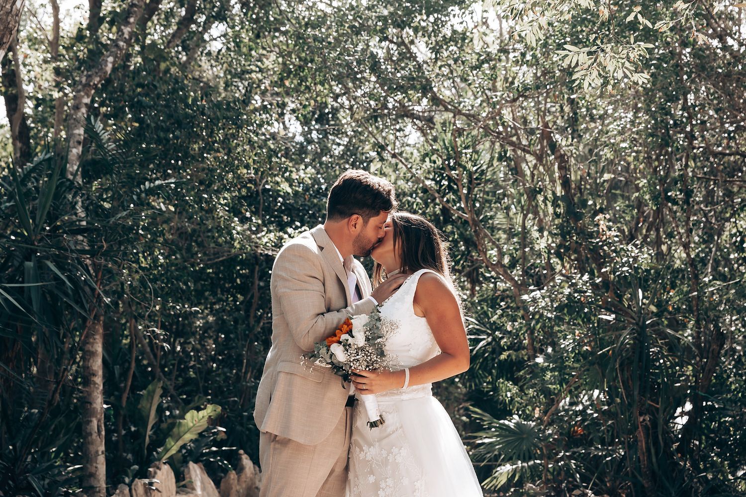 A tender moment captured between newlyweds in a serene outdoor garden setting.