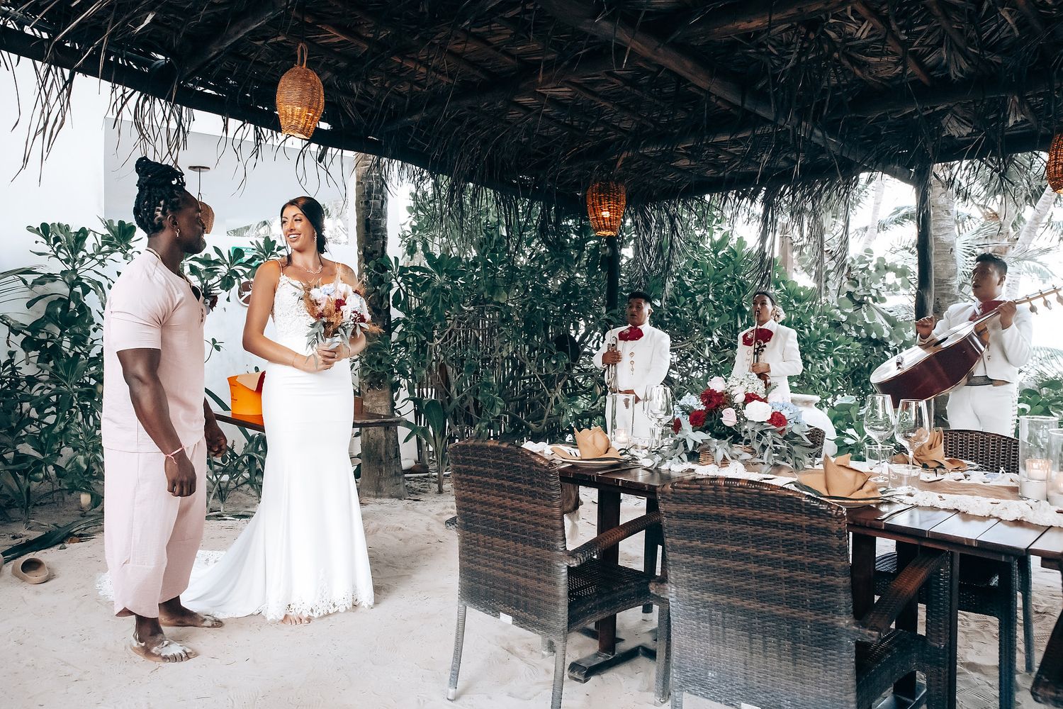 A couple stands together in an outdoor setting with a table and chairs.