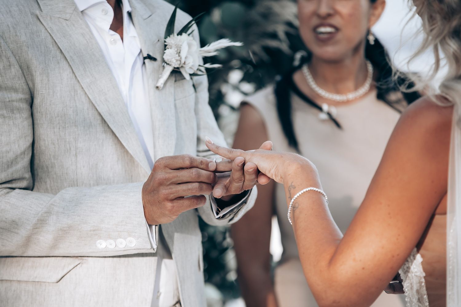 Wedding ceremony exchange with pearl necklace detail.