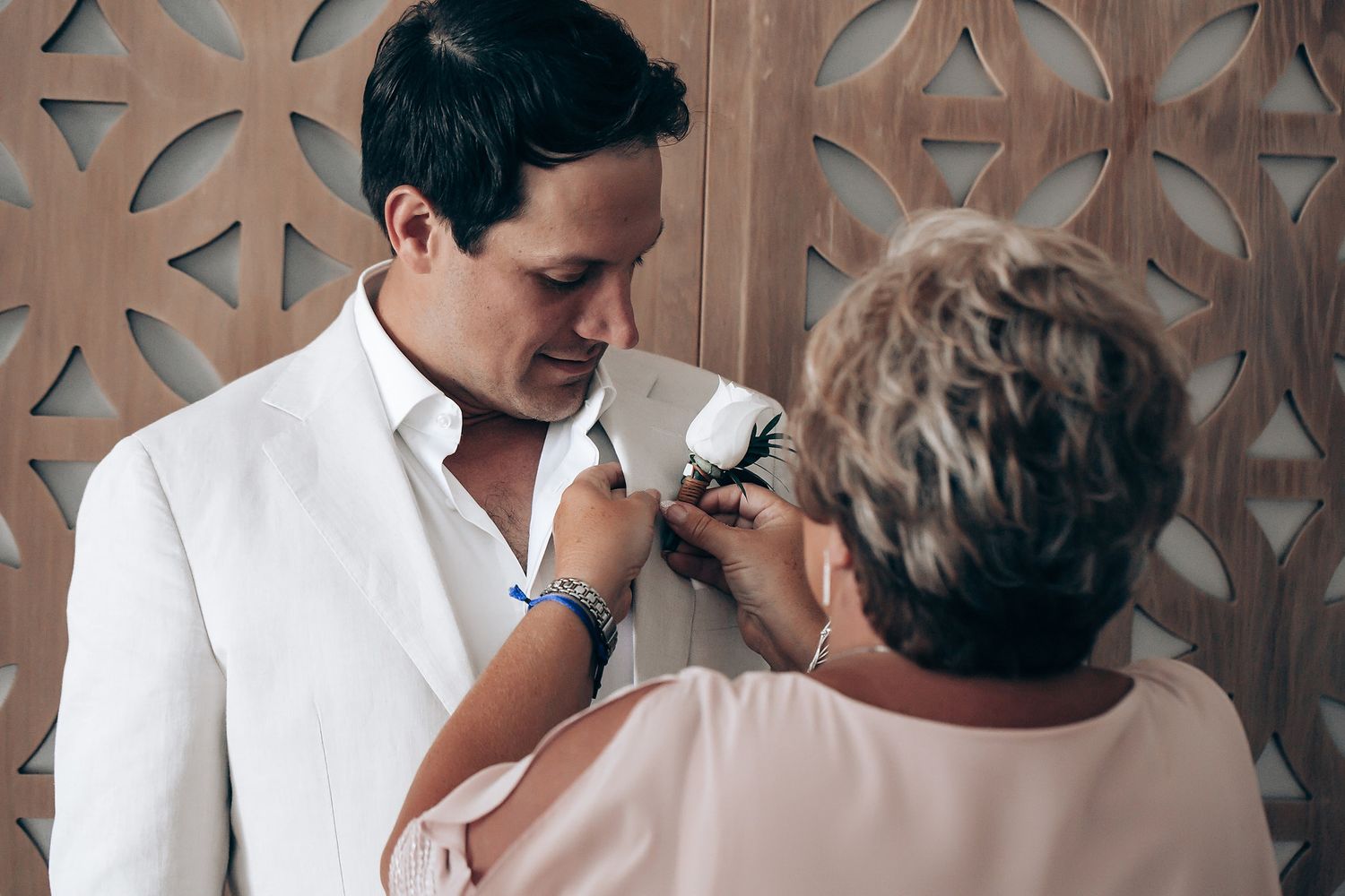 A tender moment between two people in formal attire during what appears to be a wedding celebration.