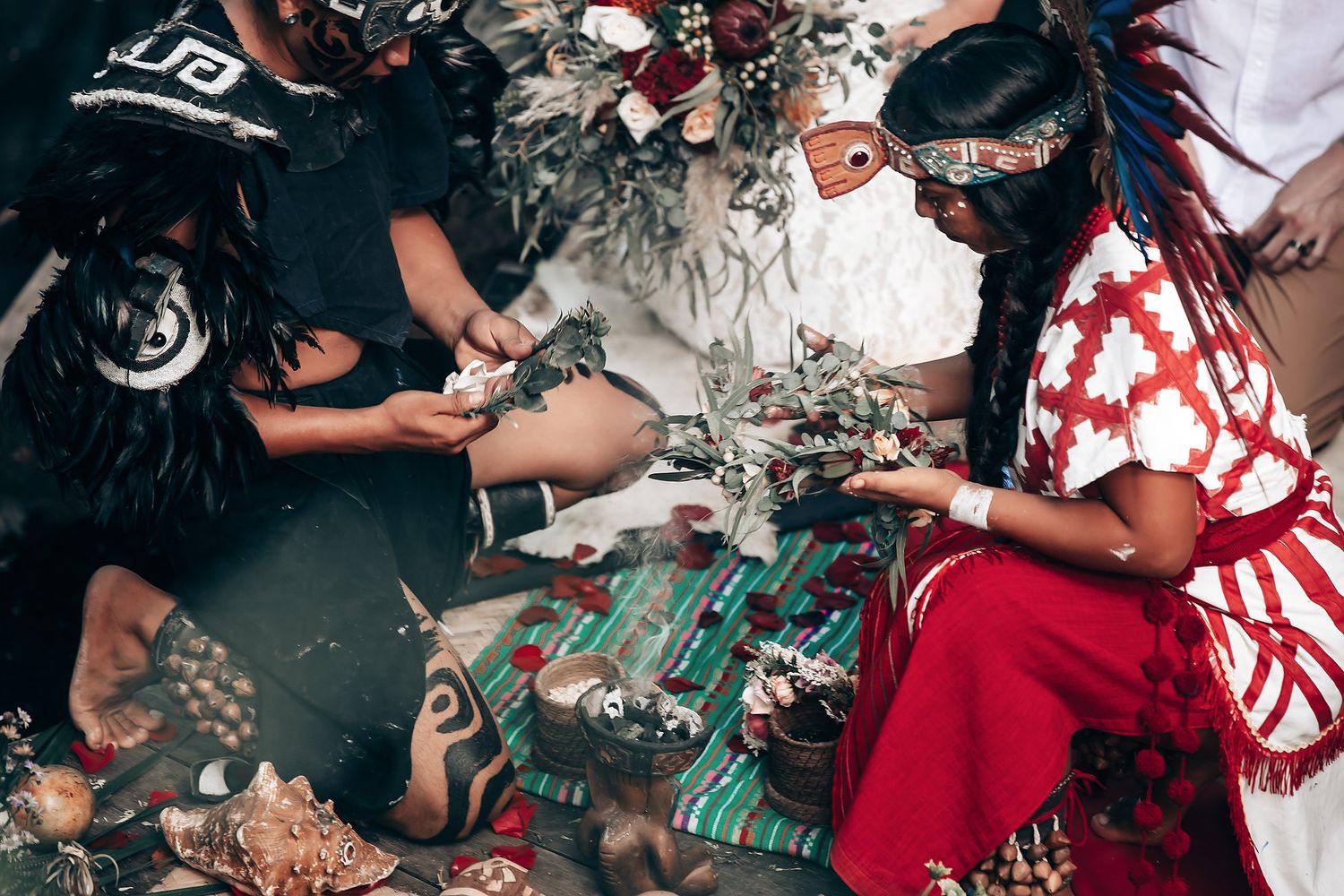 Traditional ceremony items laid out on ground with red and white decorative elements.