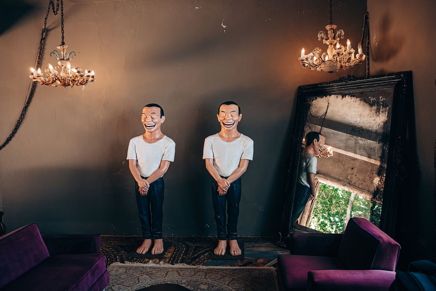 A series of moody artistic portraits in a dark room with chandelier lighting and purple furniture.