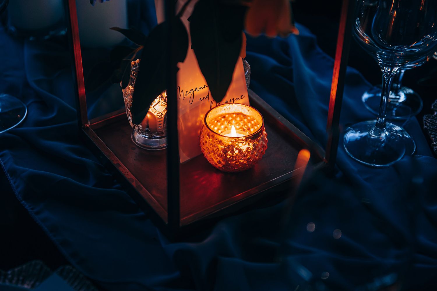 Illuminated red and orange lanterns cast a warm glow in a dark outdoor setting at night.