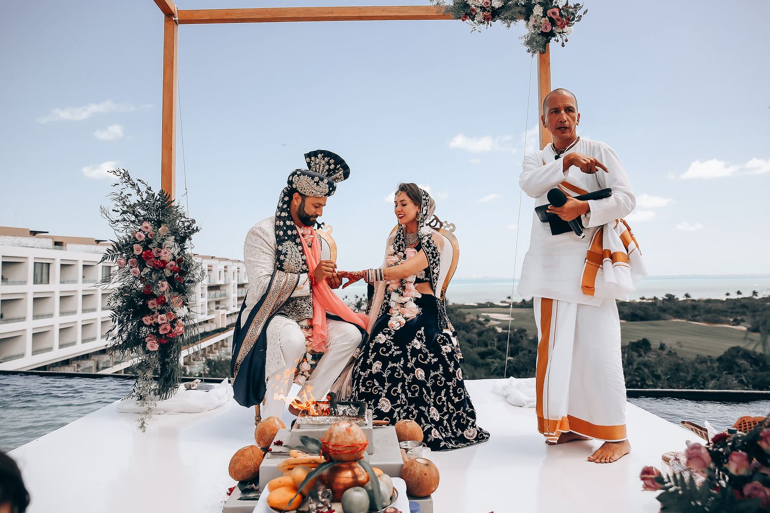 An outdoor wedding ceremony setup with wooden posts against a scenic coastal backdrop.