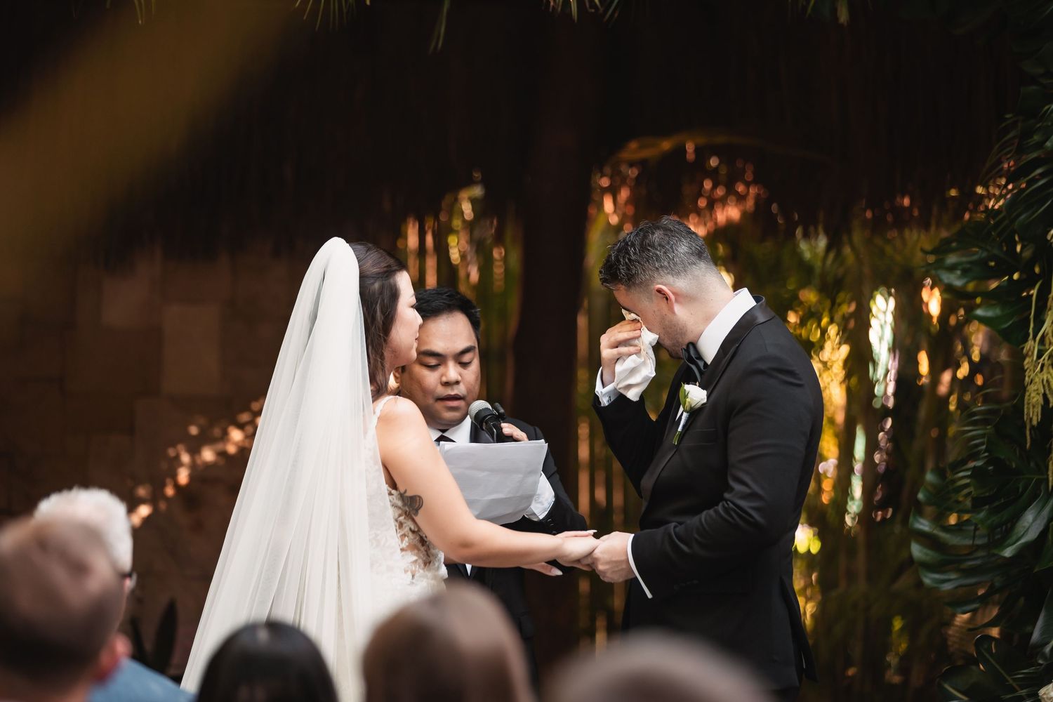 Wedding celebration in an elegant outdoor venue with palm trees and string lights.
