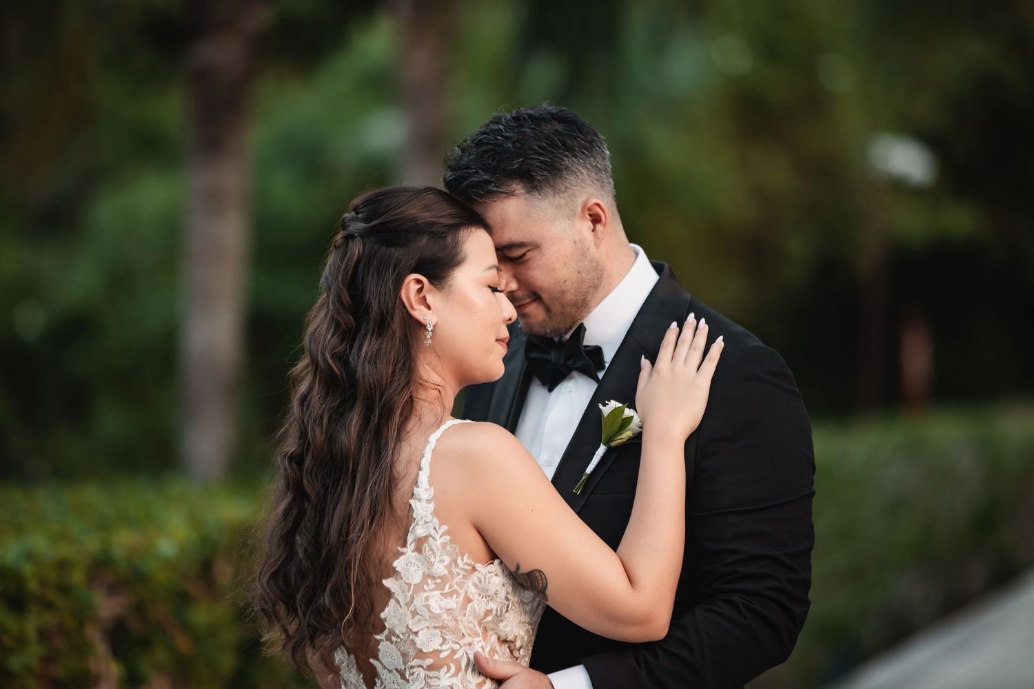 Intimate wedding portrait captured in a tropical garden setting.