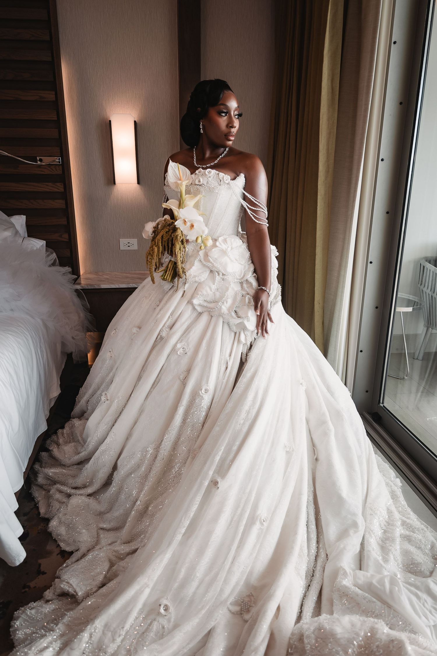 A flowing white wedding gown with intricate lace details and a dramatic train.