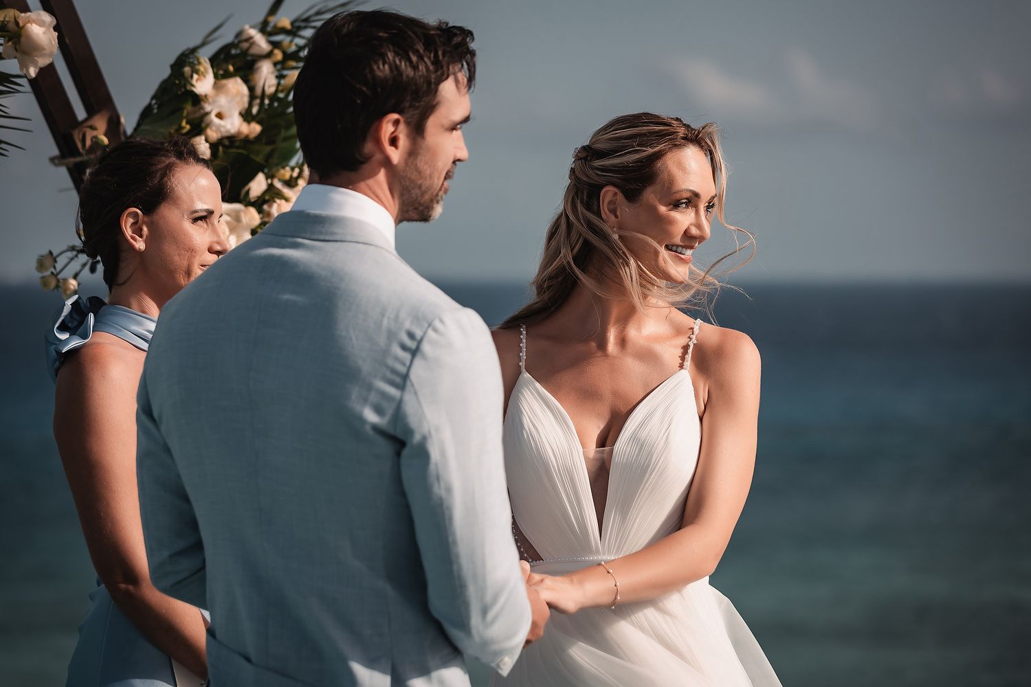 Intimate beachfront wedding ceremony moment with ocean backdrop.