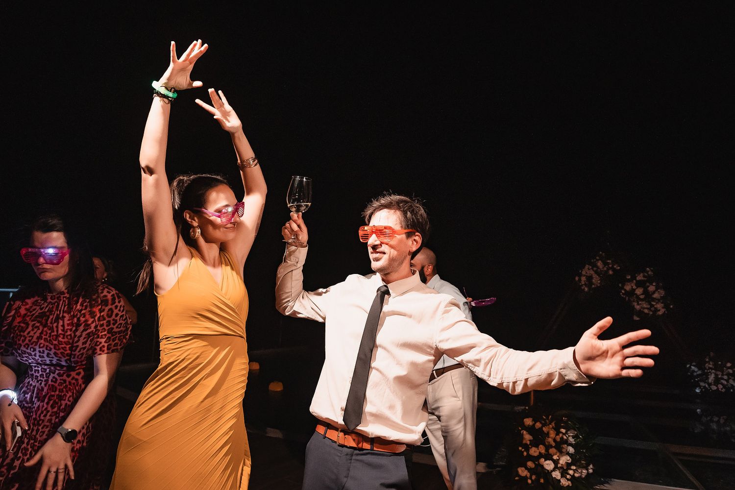 Enthusiastic dancers moving to the music at a nighttime social gathering.