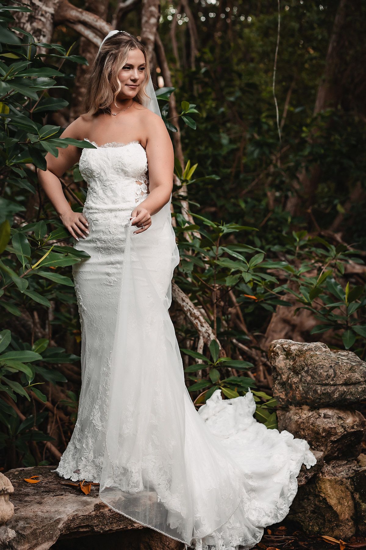 Elegant bridal portraits showcasing a detailed lace wedding gown in a forest setting.