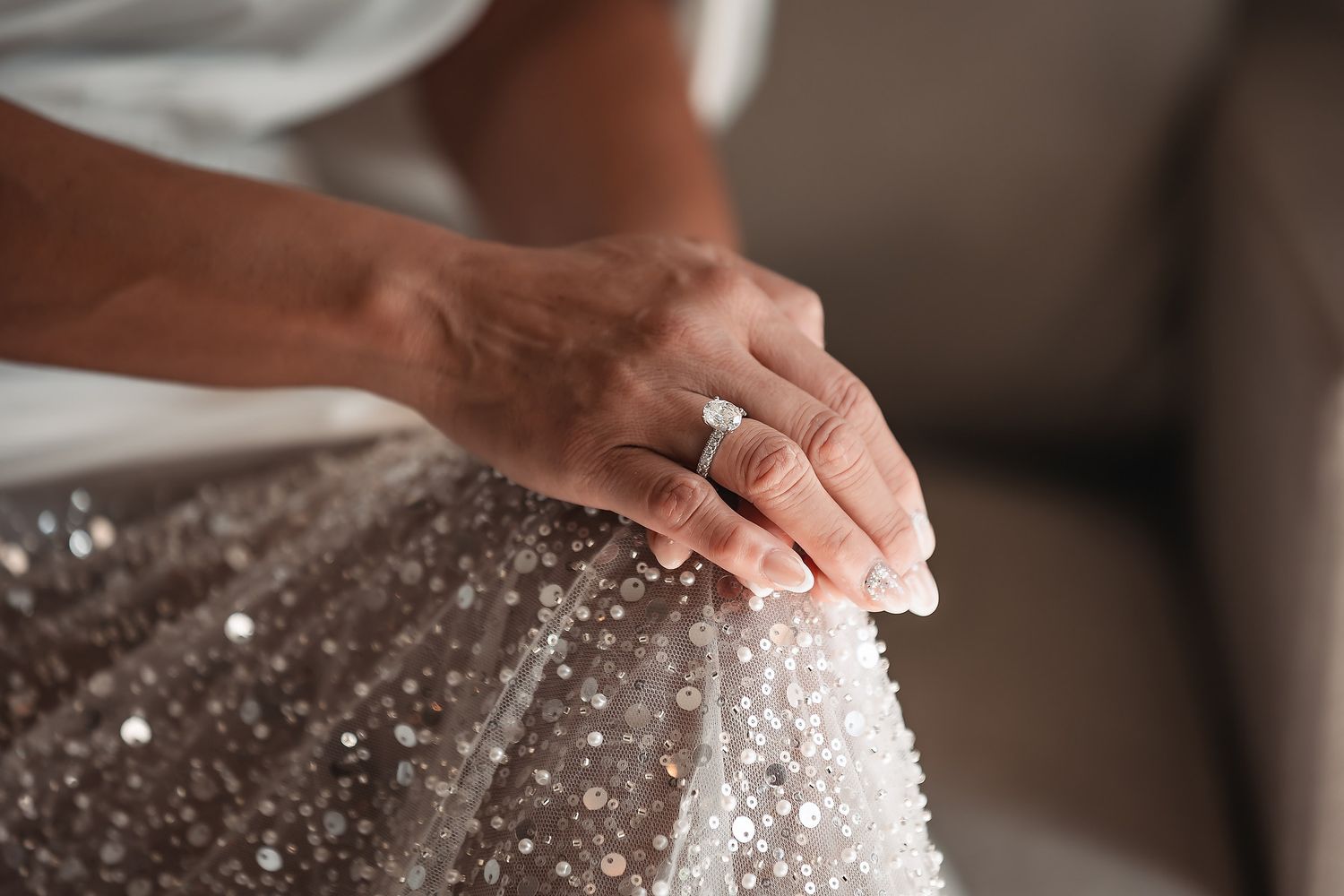 Hands sprinkling white sugar crystals onto a chocolate surface in a decorative baking process.