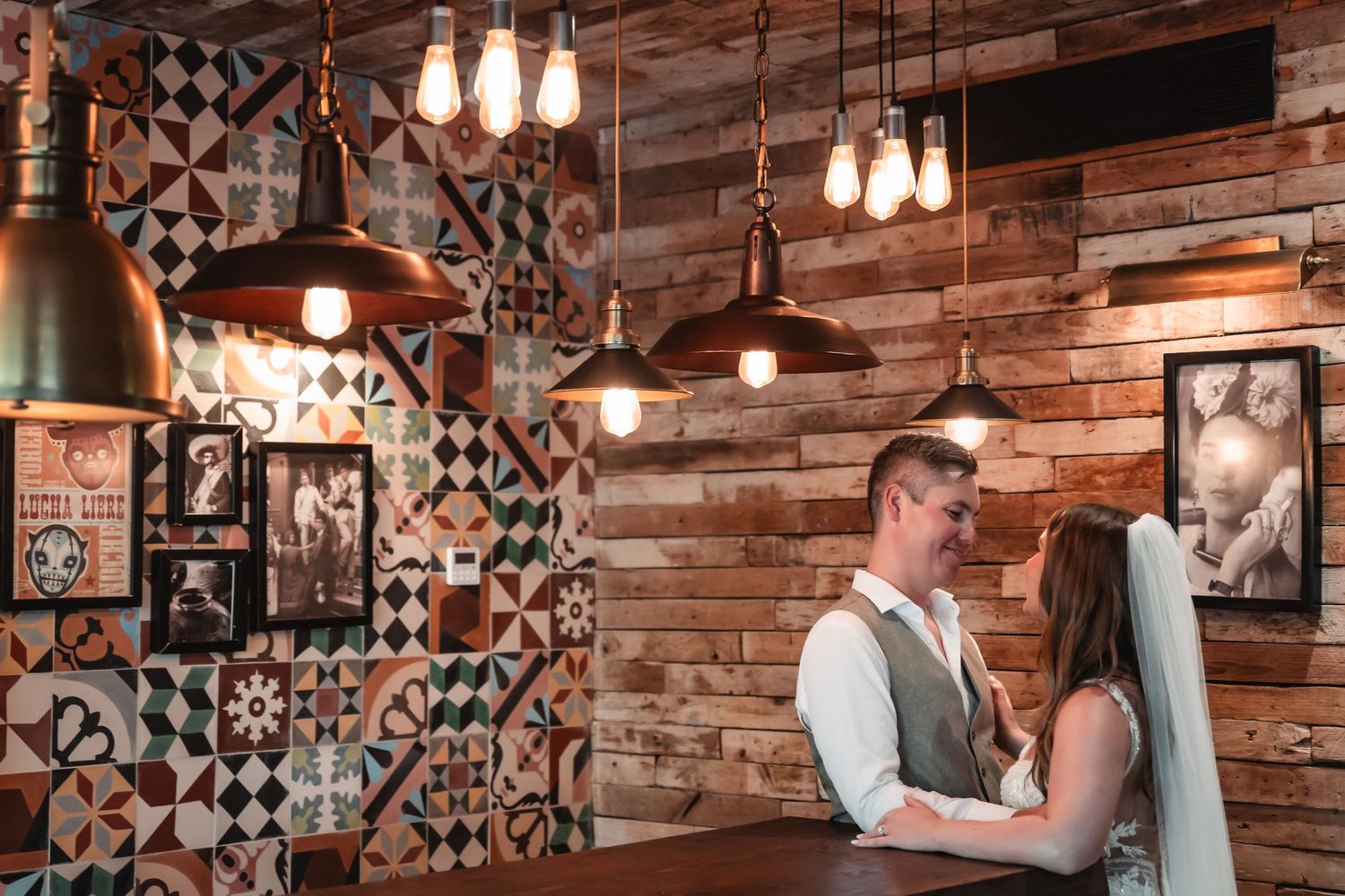 Rustic wedding venue interior with exposed brick walls and geometric tile accents.