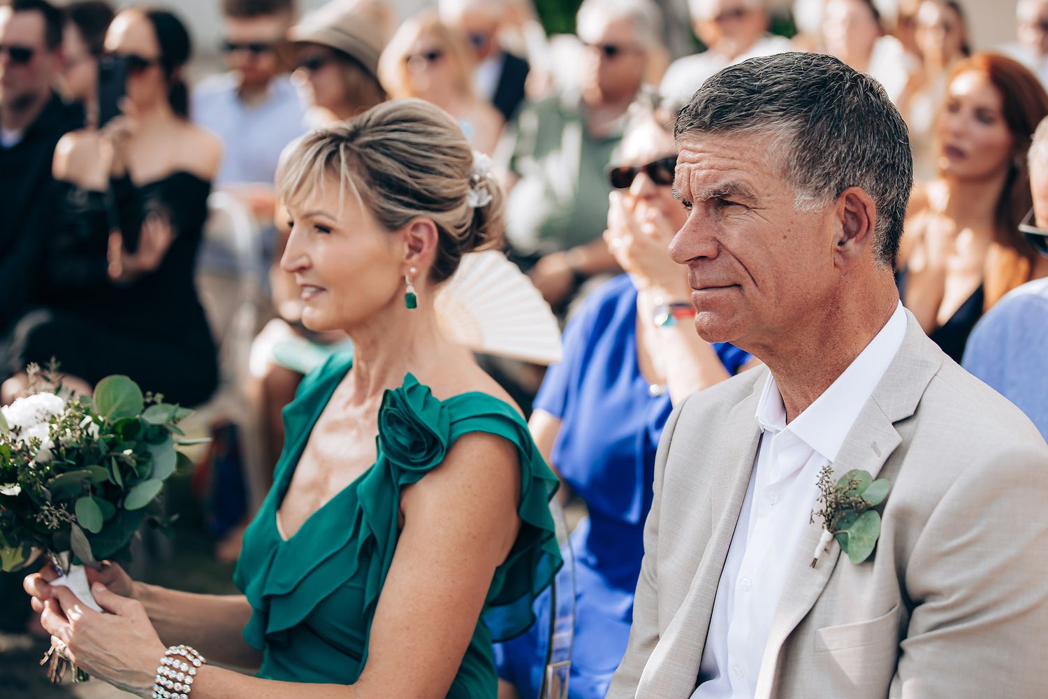 Wedding guests seated in rows watching the ceremony with expressions of joy and emotion.