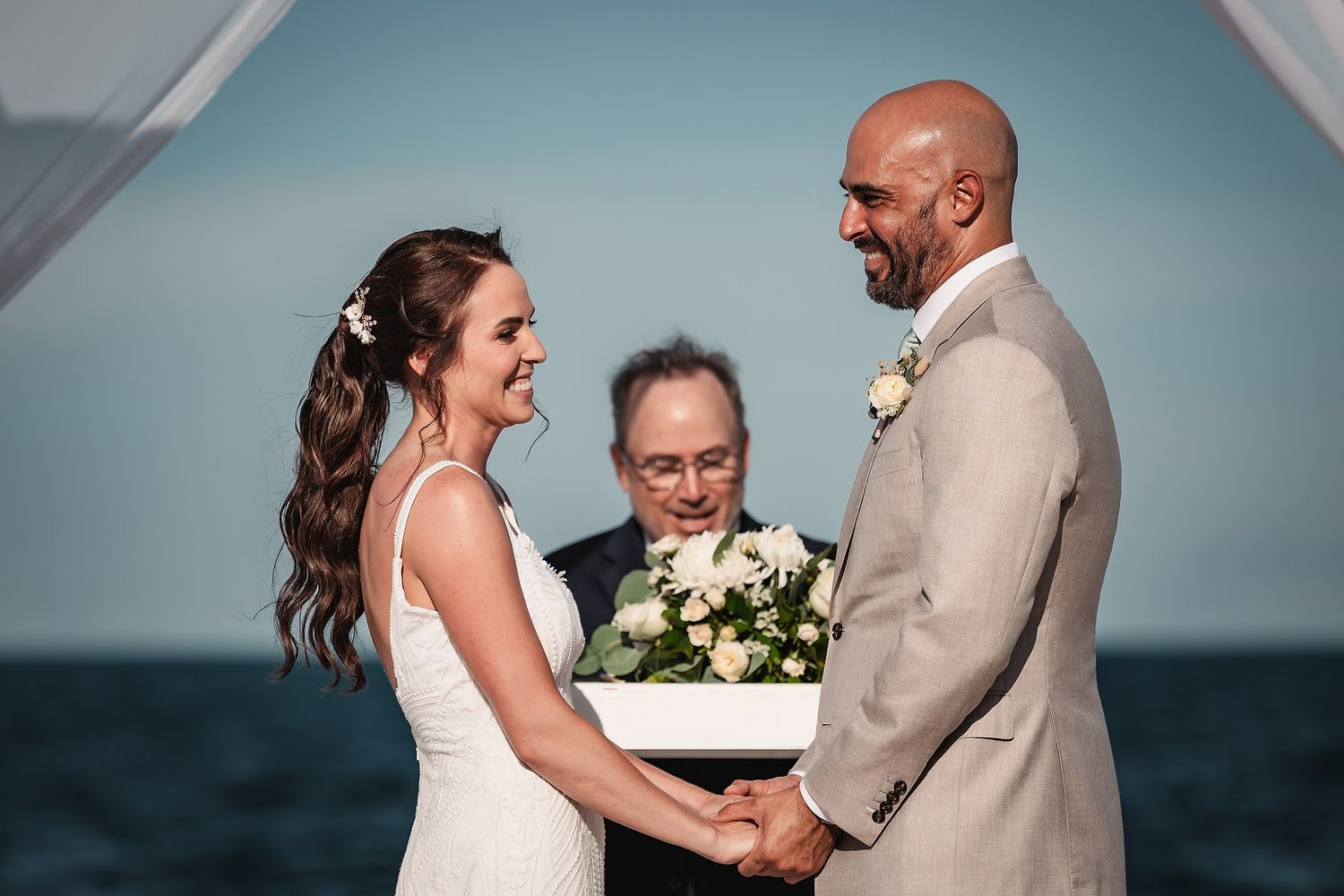 A couple shares joyful moments during their beachside wedding ceremony.
