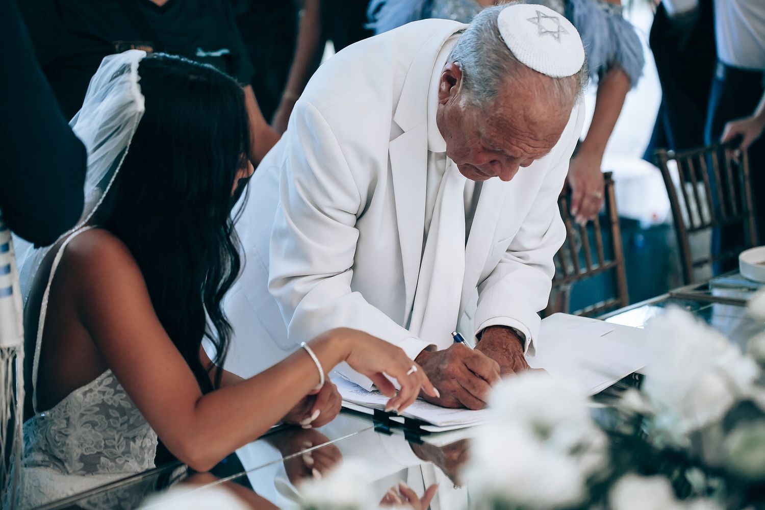 Official signing documents at an elegant outdoor event.