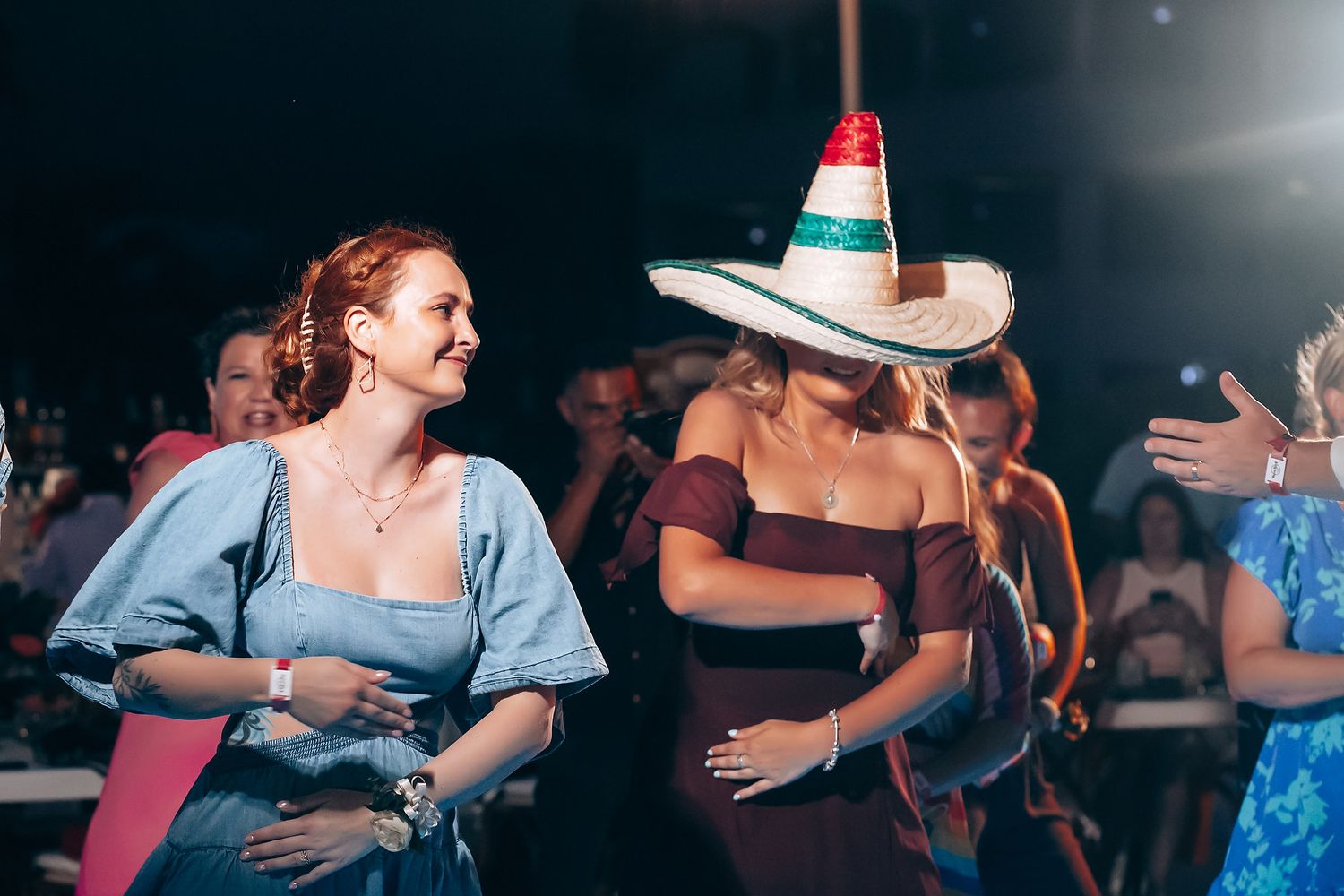 People dancing in a dimly lit indoor venue with a festive atmosphere.