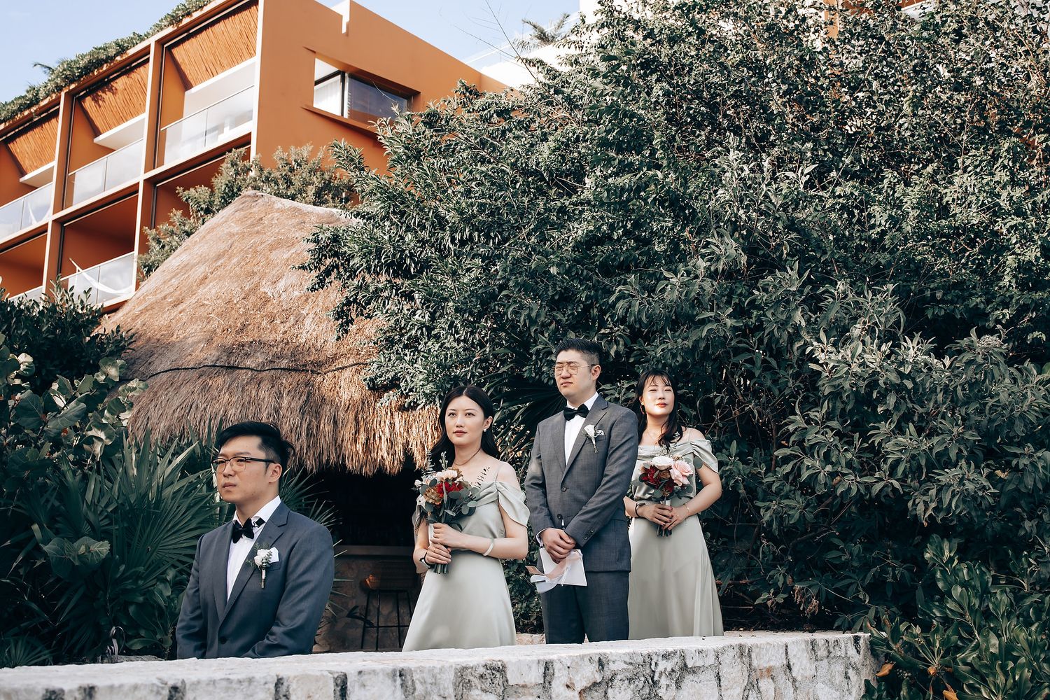 Outdoor wedding ceremony setup with natural foliage and terracotta architecture in the background.