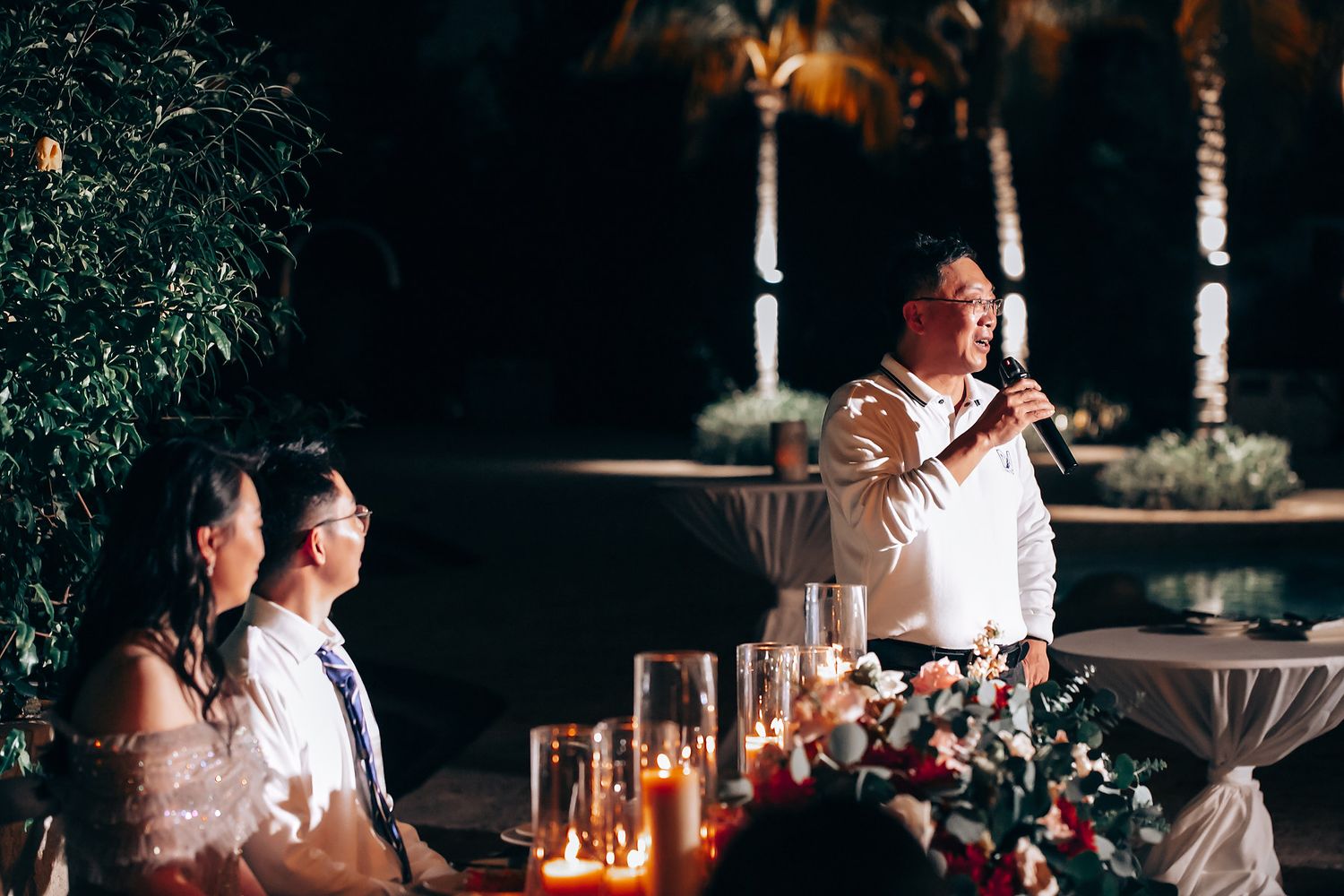 Intimate evening wedding reception with ambient lighting and decorative elements.