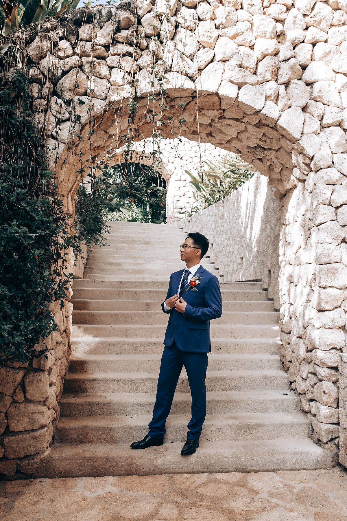A sequence of poses against a rustic stone staircase backdrop featuring someone in a blue formal suit.