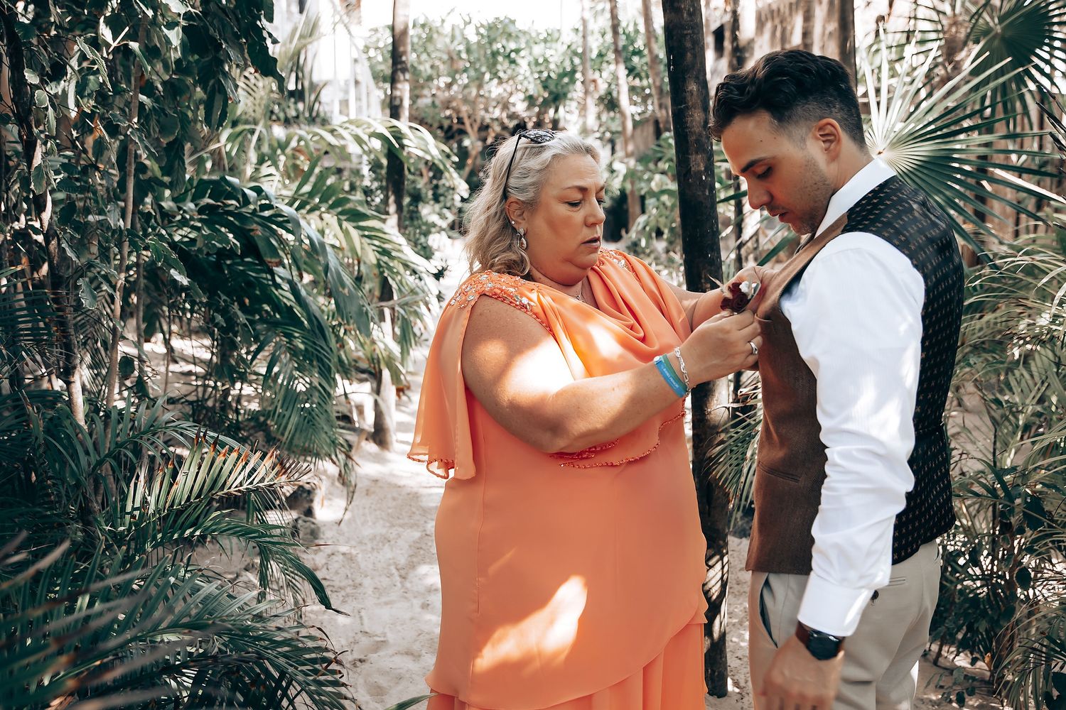 Couple embraces in a lush tropical garden setting during an intimate wedding photoshoot.