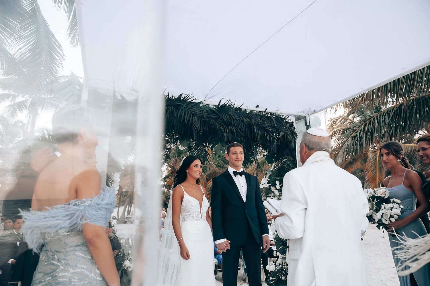 Outdoor wedding ceremony setup with white decor and ocean views.