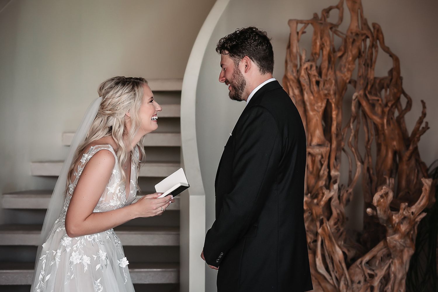 First look moment between couple during their wedding day in front of wooden art installation.