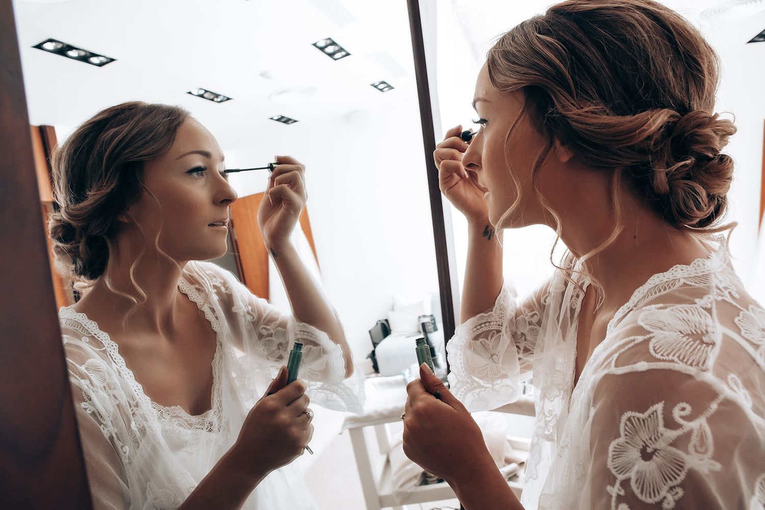 Wedding day makeup preparation in natural window light.