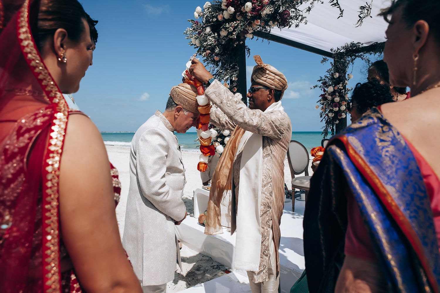 Outdoor wedding ceremony with decorative elements and blue sky backdrop.