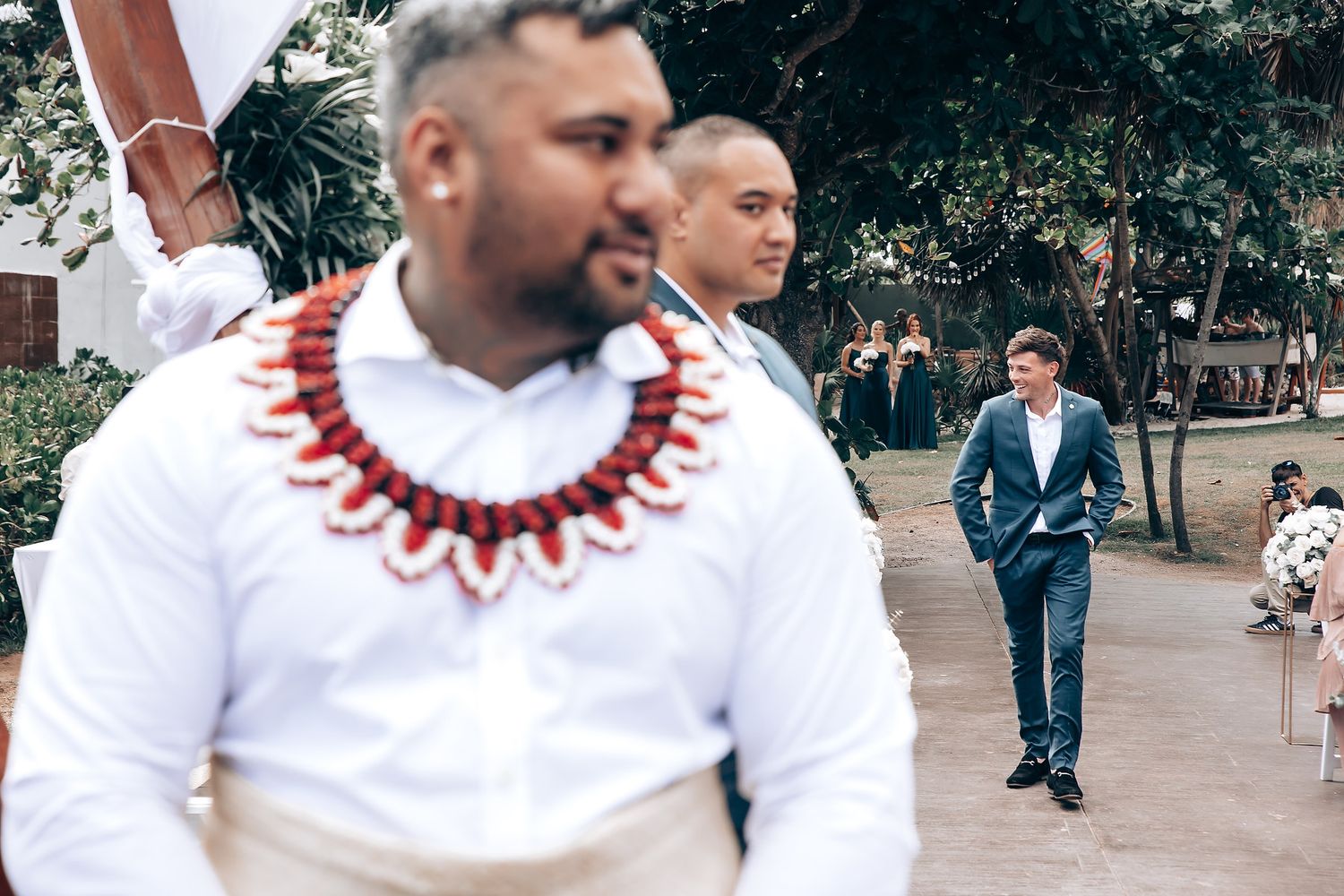Wedding ceremony decor with white and red traditional African attire against a natural backdrop.