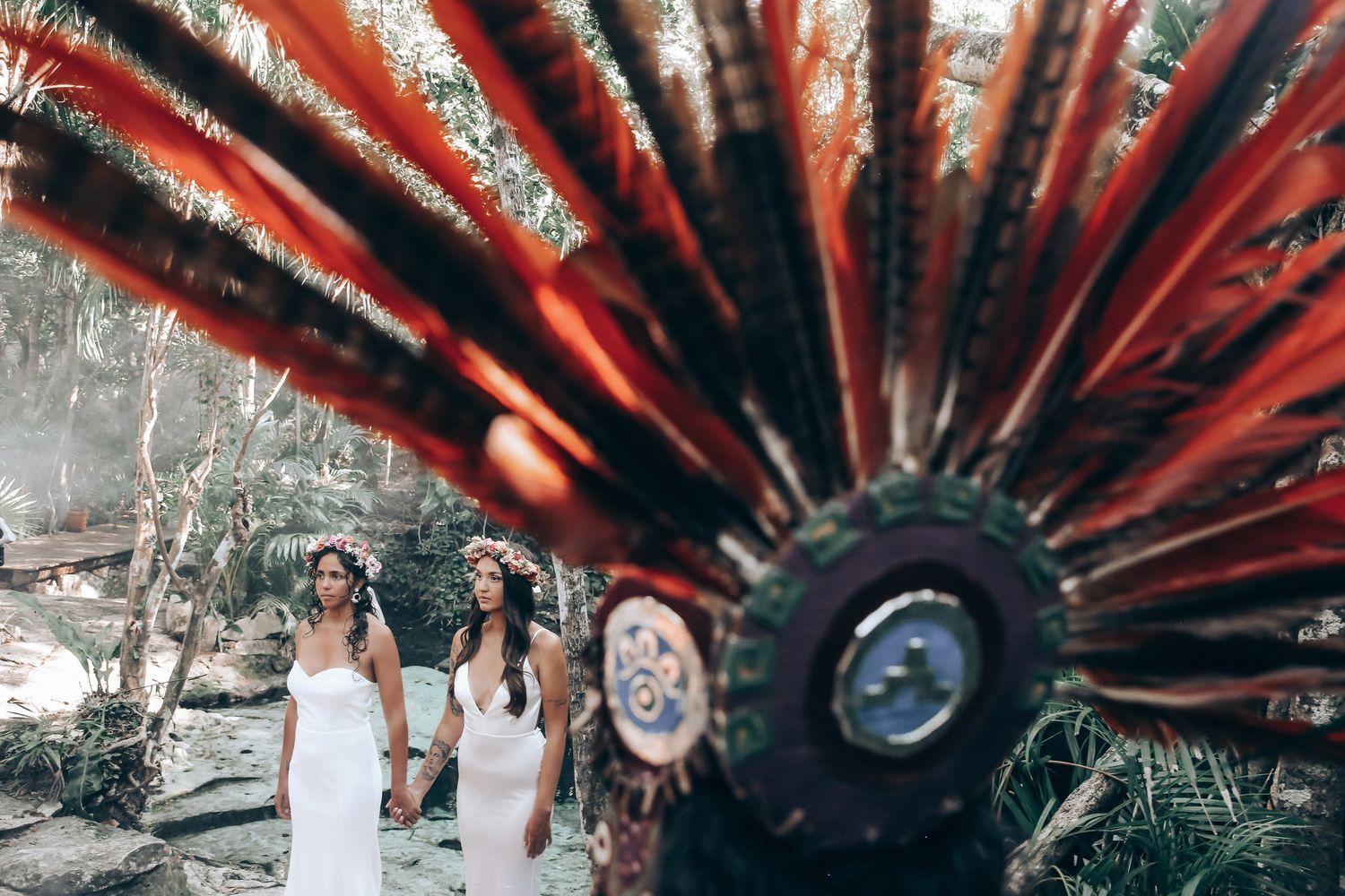 Vibrant red feathered ceremonial headdress displayed against a natural forest backdrop.