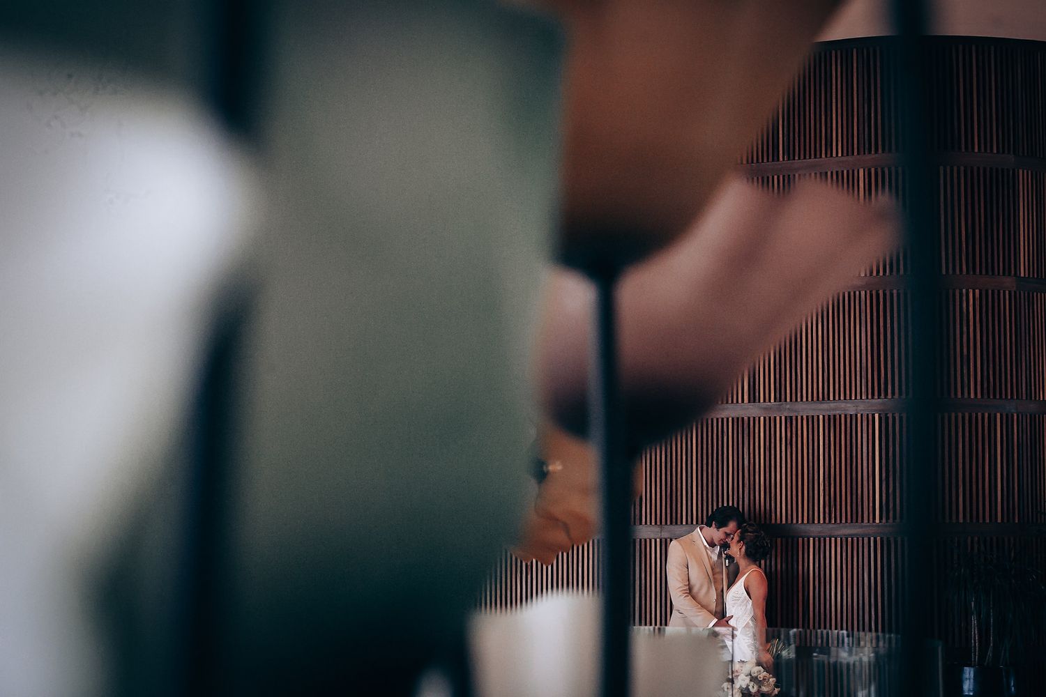 Artistic dark and moody wedding ceremony photo with bokeh lighting effects.