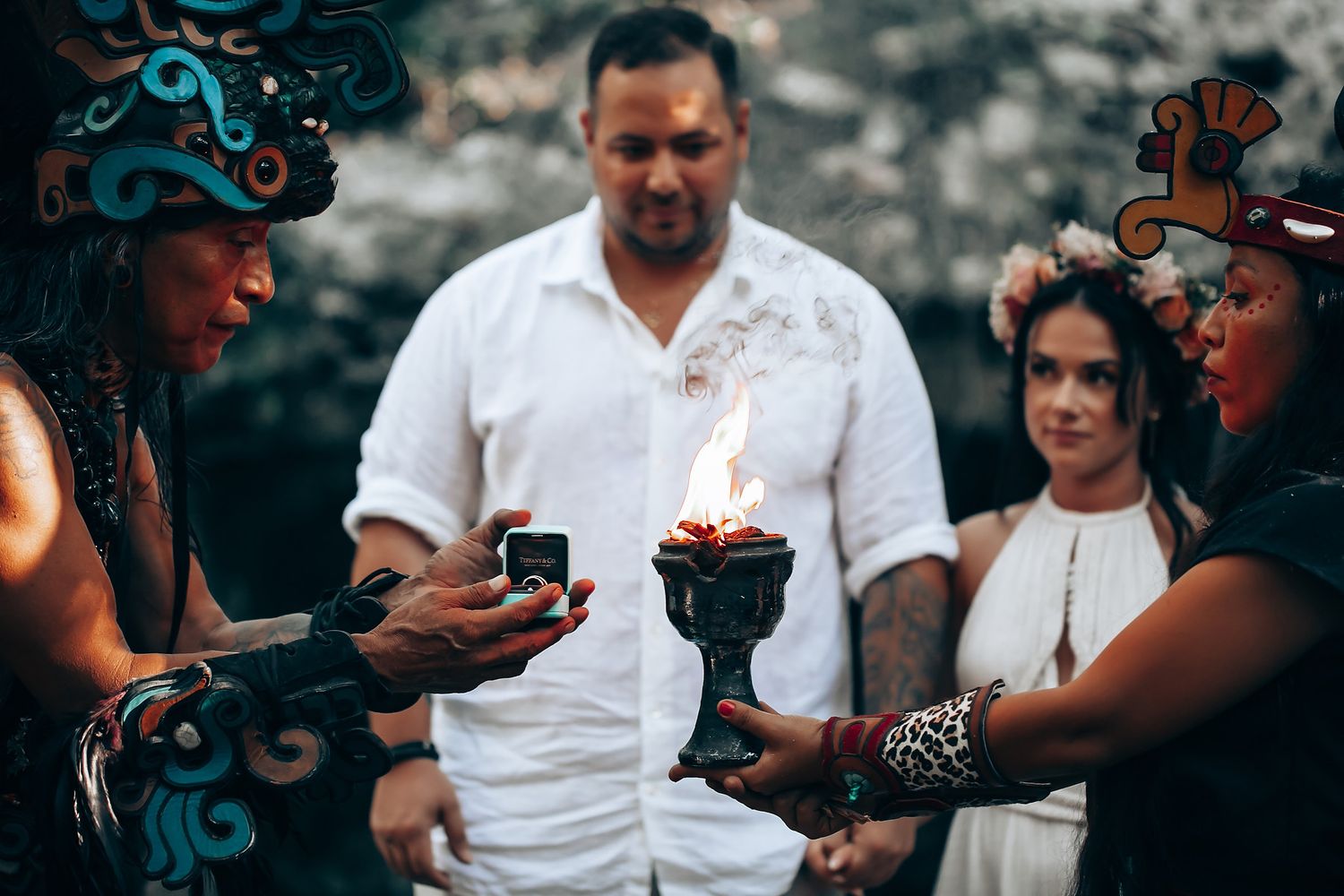 People sharing drinks and looking at phones during an outdoor gathering.