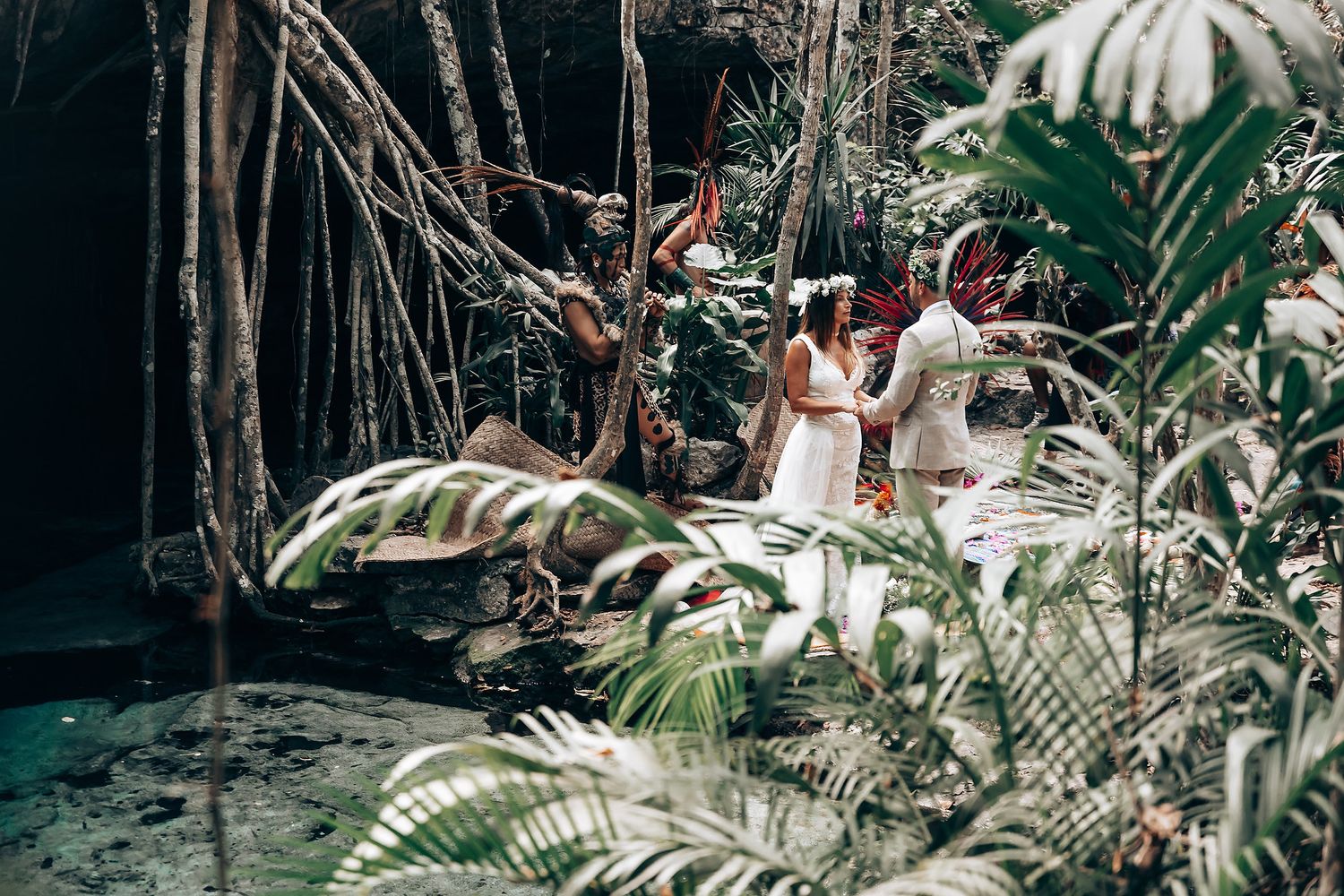 Intimate wedding ceremony surrounded by tropical foliage and palm trees in a natural garden setting.