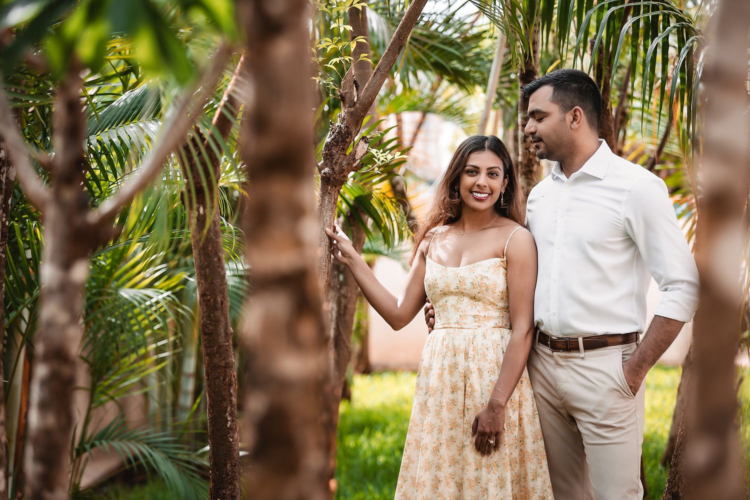 Romantic photoshoot in a tropical garden with palm trees and natural sunlight.
